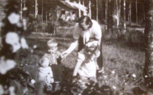 Salme  lasten kanssa pihalla  50-luvun alkupuolella. Takana mäellä Puustelli.
