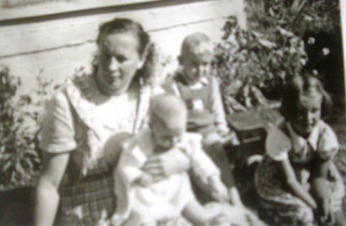 Auringossa Huuskolan eteläseinustalla Kaijan, Erkin ja Marjan kanssa.